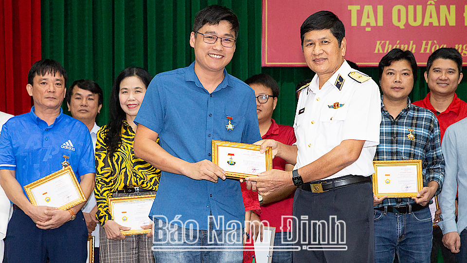 Lãnh đạo Vùng 4 Hải quân trao huy hiệu chiến sĩ Trường Sa cho phóng viên Báo Nam Định tham gia đoàn công tác.