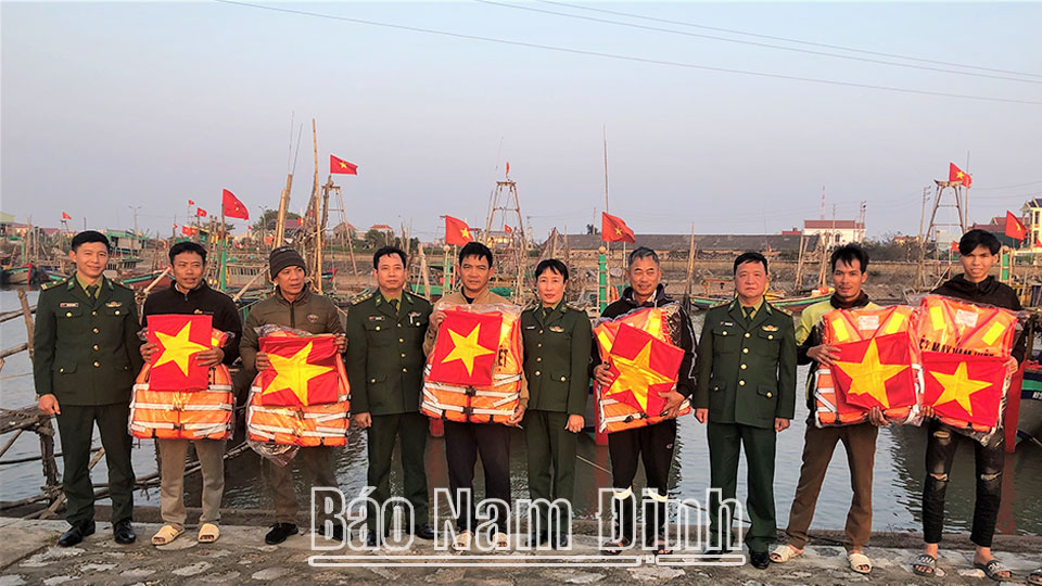 Lãnh đạo Bộ Chỉ huy BĐBP tỉnh, Đồn Biên phòng Quất Lâm trao tặng Cờ Tổ quốc, áo phao, quà Tết cho ngư dân.