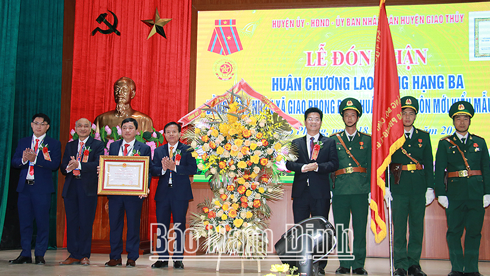 Đồng chí Phó Chủ tịch Thường trực UBND tỉnh Trần Anh Dũng trao tặng Huân chương Lao động hạng Ba và lẵng hoa tươi thắm chúc mừng Đảng bộ, chính quyền và nhân dân xã Giao Phong.