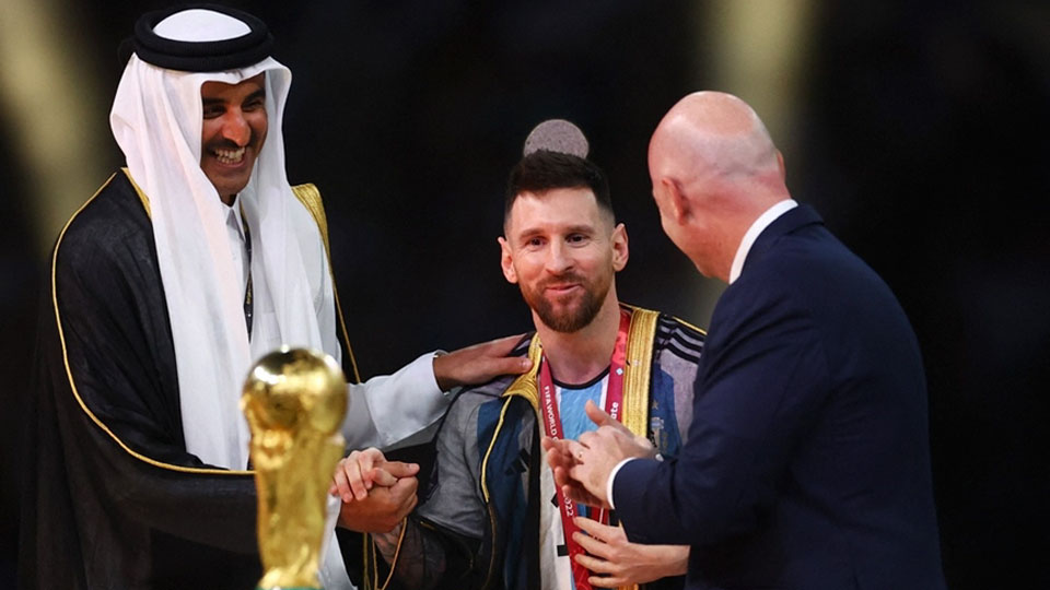 Tiểu vương Qatar Sheikh Tamim bin Hamad Al Thani mặc lên người Messi chiếc áo khoác đặc biệt. 
Ảnh: Getty 
