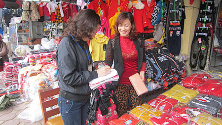 Cán bộ Đội thuế khu vực chợ Rồng (TP Nam Định) thu thuế môn bài năm 2014 của các hộ kinh doanh. 
