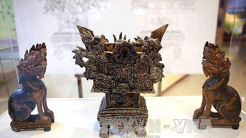Hình tượng con nghê của Việt Nam trên lư hương bằng gốm thế kỷ XIX và nghê bằng gỗ thế kỷ XIX được trưng bày tại một triển lãm. Ảnh: Trần Lê Lâm - TTXVN
