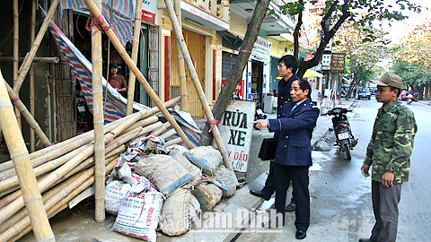 Đội quản lý trật tự đô thị thành phố nhắc nhở người dân dọn dẹp phế thải xây dựng lấn chiếm vỉa hè trên đường Tô Hiệu, phường Ngô Quyền.