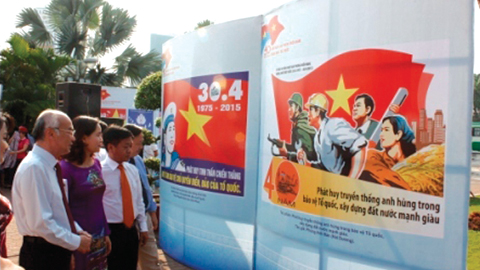 Người dân đến xem Triển lãm Tranh cổ động kỷ niệm 40 năm Giải phóng miền Nam và 125 năm Ngày sinh Chủ tịch Hồ Chí Minh. Ảnh: PV