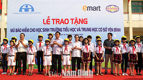 Các đồng chí lãnh đạo Bộ GTVT, lãnh đạo tỉnh Nam Định tặng mũ bảo hiểm cho học sinh các trường tiểu học, THCS xã Yên Bình (Ý Yên).