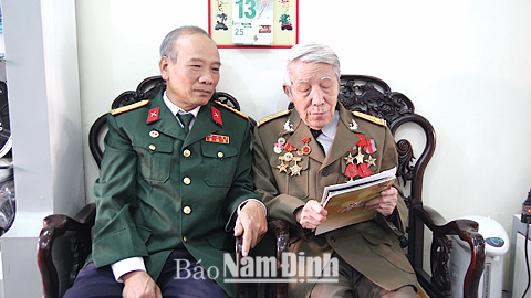 CCB Trần Minh Công (bên phải) cùng với đồng đội ôn lại kỷ niệm chiến đấu.