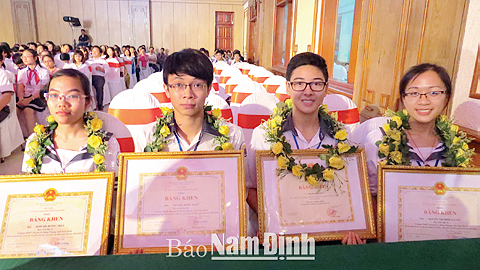 Các em Đinh Thị Hương Thảo, Phạm Minh Đức (thứ nhất và thứ ba từ trái sang) trong lễ tuyên dương học sinh giỏi quốc gia, quốc tế năm 2015 của tỉnh.
