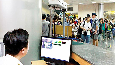 Sử dụng máy đo thân nhiệt để kiểm tra khách nhập cảnh tại sân bay Nội Bài