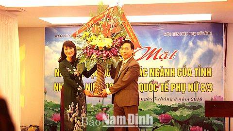 Đồng chí Trần Văn Chung, Phó Bí thư Thường trực Tỉnh ủy, Chủ tịch HĐND tỉnh tặng hoa đại diện nữ cán bộ quản lý của tỉnh tại buổi gặp mặt.