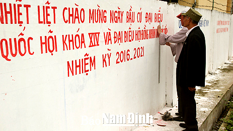 Nhân dân xã Hải Cường (Hải Hậu) kẻ, vẽ khẩu hiệu tuyên truyền bầu cử. 