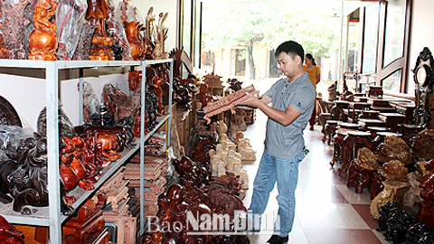 Du khách lựa chọn hàng thủ công mỹ nghệ tại làng nghề chạm khắc gỗ La Xuyên, xã Yên Ninh (Ý Yên).