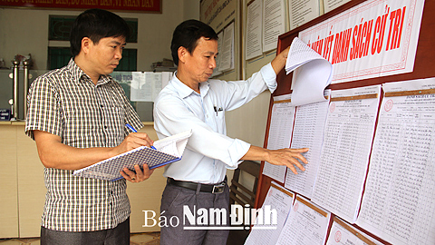 Cán bộ xã Hải Hưng kiểm tra việc niêm yết danh sách cử tri tại các khu vực bầu cử.