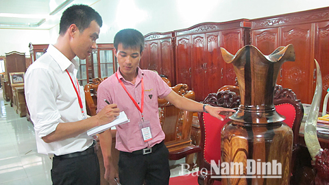 Cán bộ Trung tâm phát triển nông thôn Việt hướng dẫn các hộ dân làng nghề La Xuyên (Ý Yên) quy trình xây dựng Nhãn hiệu chứng nhận cho sản phẩm đồ gỗ La Xuyên.