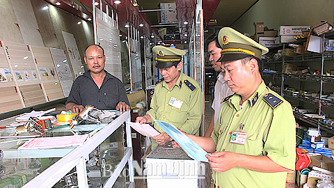 Lực lượng QLTT huyện Nghĩa Hưng hướng dẫn các hộ kinh doanh trên địa bàn ký cam kết không kinh doanh hàng cấm, hàng giả, hàng nhái.
