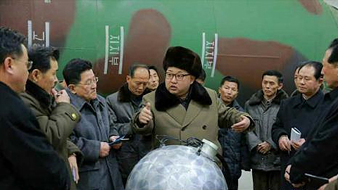 Nhà lãnh đạo Triều Tiên Kim Jong Un (giữa) trong một cuộc gặp với các nhà khoa học và kỹ thuật viên trước mô hình một phần đầu đạn hạt nhân thu nhỏ ngày 9/3. Ảnh: Yonhap/TTXVN