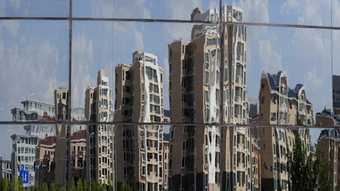 Hình ảnh những tòa chung cư vắng lặng ở “thành phố ma” Ordos phản chiếu qua gương. Ảnh: AFP