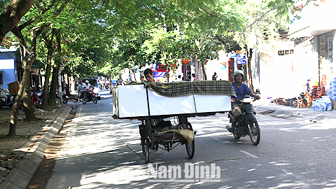 Xe xích lô chở hàng hóa cồng kềnh cản trở tầm nhìn của người tham gia giao thông. (Ảnh chụp tại đường Hàn Thuyên, TP Nam Định).