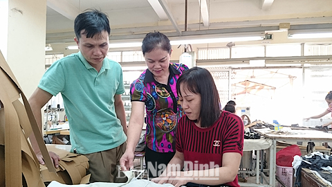 Giám đốc Vũ Thị Hồng Chuyên (đứng giữa), Cty CP May 2 (Tổng Cty CP Dệt may Nam Định) kiểm tra, hướng dẫn công nhân sản xuất. 