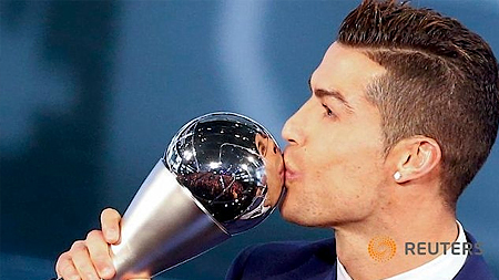 Cristiano Ronaldo ăn mừng sau khi nhận chiếc cúp "FIFA The Best" từ tay Chủ tịch FIFA Gianni Infantino. Ảnh: Reuters