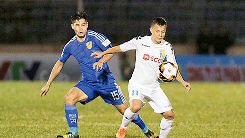 Pha tranh bóng giữa cầu thủ hai đội QNK Quảng Nam (áo xanh) và Hà Nội FC.