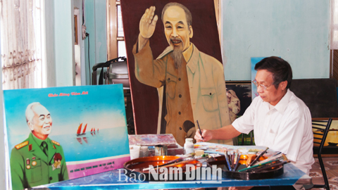 Nghệ nhân Đinh Khắc Tuyến bên tác phẩm bức tranh chân dung Bác Hồ và Đại tướng Võ Nguyên Giáp.