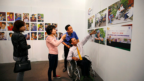 Tác giả và khách mời chiêm ngưỡng những bức ảnh tại triển lãm- Ảnh: Nam Trần