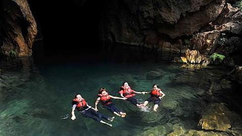 Du khách thích thú khi được đắm mình trong làn nước mát ở hang E (Vườn quốc gia Phong Nha - Kẻ Bàng).