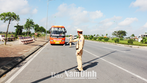 Cán bộ, chiến sĩ Phòng Cảnh sát giao thông đường bộ - đường sắt (Công an tỉnh) kiểm tra việc chấp hành quy định vận tải của xe khách trên Đại lộ Thiên Trường.