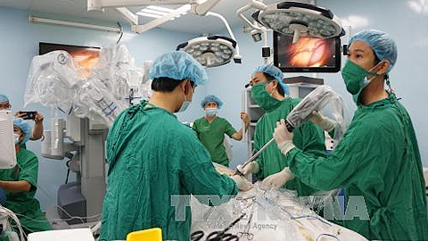 Ê kíp bác sĩ đưa camera vào ổ bụng bệnh nhân để chuẩn bị thực hiện phẫu thuật ca ung thư dạ dày đầu tiên bằng Robot. Ảnh: Phương Vy/TTXVN.