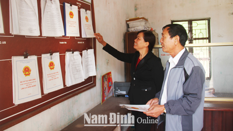Người dân tra cứu thông tin trên bảng niêm yết công khai thủ tục hành chính tại bộ phận một cửa xã Xuân Đài.