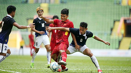 Pha tranh bóng giữa cầu thủ hai đội U22 Việt Nam (áo đỏ) và U22 Cam-pu-chia.