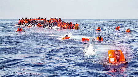 Người di cư cố gắng tiếp cận thuyền cứu hộ ở ngoài khơi thị trấn Sabratha, Libya. (Ảnh: AP)