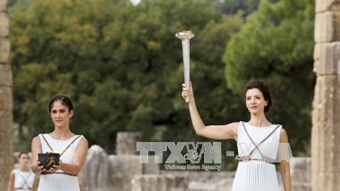 Nữ diễn viên Hy Lạp Katerina Lehou (phải) tại buổi diễn tập thắp đuốc Olympic ở núi Olympia ngày 23-10.