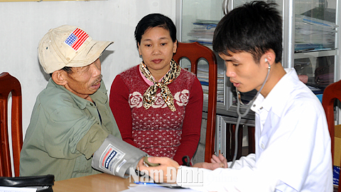 Cán bộ Trạm Y tế xã Bạch Long (Giao Thủy) khám bệnh cho người có thẻ BHYT.