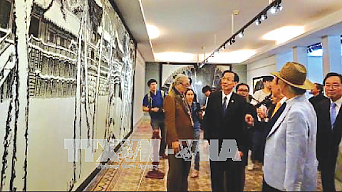 Khách mời và công chúng đến tham quan và tìm hiểu các tác phẩm nghệ thuật Việt - Hàn trong ngày khai mạc triển lãm. Ảnh: TTXVN