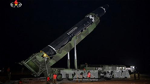 Tên lửa liên lục địa được đặt vào bệ phóng di động ở Triều Tiên, chuẩn bị cho vụ phóng (do Đài truyền hình Trung ương Triều Tiên đăng phát ngày 30/11). Ảnh: YONHAP/TTXVN