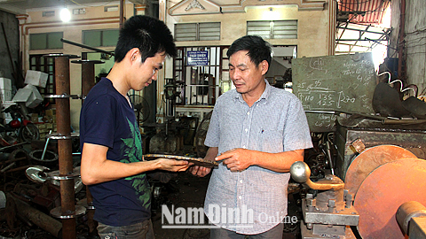 Ông Nguyễn Thanh Thịnh (bên phải) giám đốc Cty TNHH Thái Thịnh, xóm Tân Lập, xã Hải Xuân kiểm tra kỹ thuật chi tiết máy trong sản xuất tời thu lưới cho tàu cá.