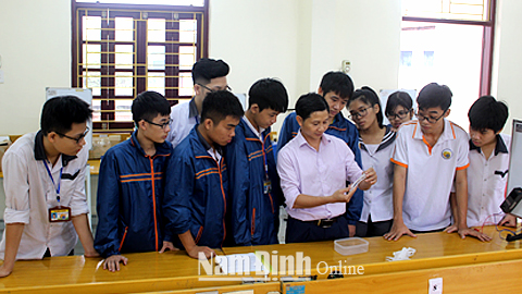 Thầy giáo Nguyễn Văn Huyên và các em học sinh đội tuyển học sinh giỏi quốc gia môn Vật lý trong giờ thực hành.