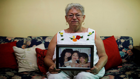 Bà Maria Gloria Ceren de Quinonez và bức ảnh chụp cùng con gái, cháu ngoại - những người đang sống tại Mỹ theo diện TPS, trong căn nhà tại El Salvador ngày 8/1. Ảnh: Reuters