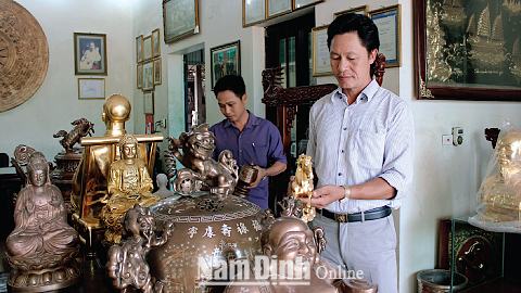 ghệ nhân Dương Bá Dũng, Giám đốc Cty TNHH Cơ khí đúc Bá Dũng, Thị trấn Lâm, huyện Ý Yên (ảnh bên phải) đang hướng dẫn công nhân hoàn thiện sản phẩm.