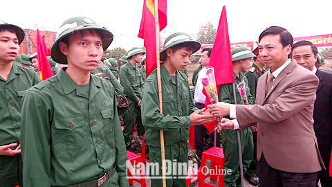 Đồng chí Trần Văn Chung, Phó Bí thư Thường trực Tỉnh uỷ, Chủ tịch HĐND tỉnh tặng hoa chúc mừng các tân binh huyện Xuân Trường