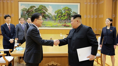 Nhà lãnh đạo Triều Tiên Kim Jong-un (bên phải) cầm lá thư của Tổng thống Hàn Quốc Moon Jae-in và bắt tay với ông Chung Eui-yong, trưởng đoàn đặc phái viên Hàn Quốc tới Triều Tiên. (Ảnh: KCNA/Reuters)