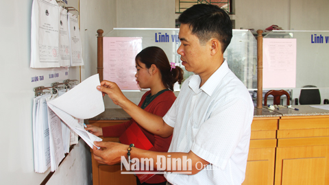 Người dân tìm hiểu các thủ tục hành chính tại Trung tâm Giao dịch hành chính “một cửa” huyện Xuân Trường.