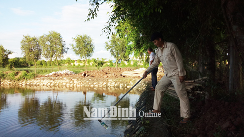 Nhân viên Trạm xử lý nước thải CCN An Xá (TP Nam Định) kiểm tra chất lượng nước thải sau xử lý tại hồ sơ lắng trước khi xả ra ngoài môi trường.