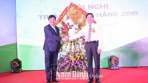 Đồng chí Trần Văn Chung, Phó Bí thư Thường trực Tỉnh ủy, Chủ tịch HĐND tỉnh tặng hoa, chúc mừng tập thể Chi nhánh VietcomBank Nam Định.
