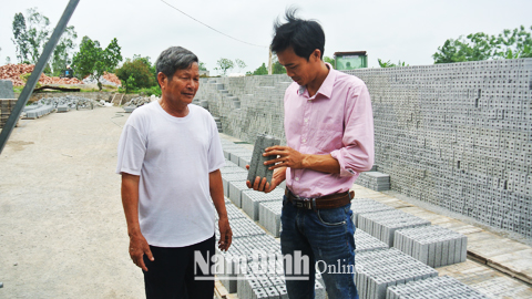 Từ làm gạch thủ công truyền thống, ông Trần Đình Kế (bên trái) ở thôn Lang Xá, xã Mỹ Tiến (Mỹ Lộc) đã chuyển đổi sang sản xuất gạch không nung thu hiệu quả kinh tế cao.
