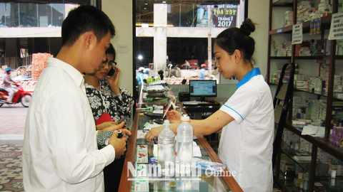 Người dân mua thuốc tại một quầy thuốc trên đường Điện Biên (TP Nam Định).