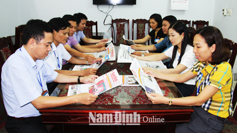 Cán bộ phường Thống Nhất theo dõi thông tin trên báo Đảng.
