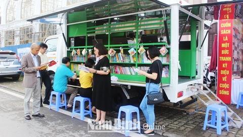 Cán bộ Thư viện tỉnh phục vụ bạn đọc bằng xe thư viện lưu động nhân Ngày Sách Việt Nam năm 2018.
