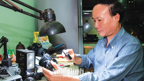 Ông Nguyễn Văn Hòa đang sửa máy ảnh.
